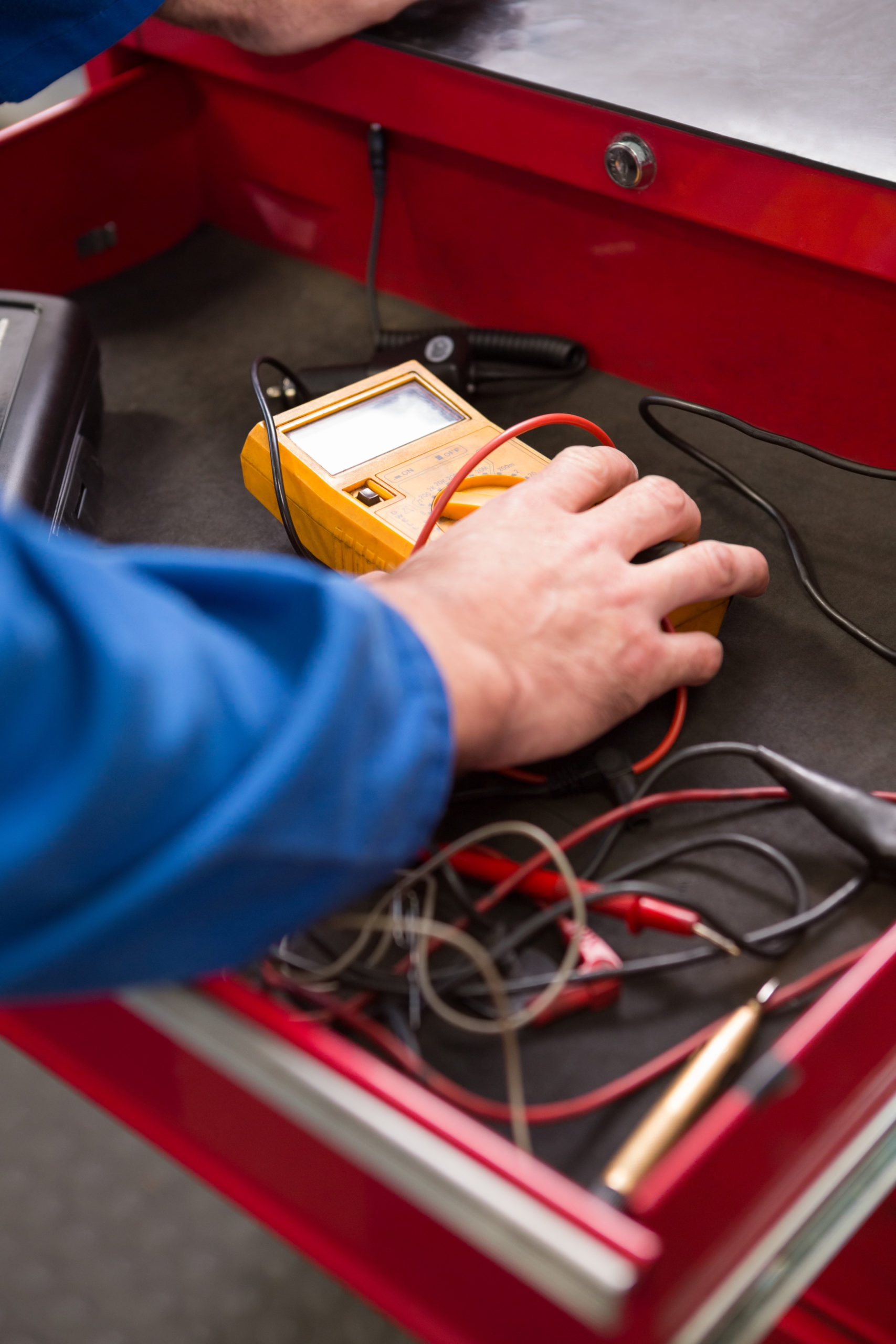 Mechanic taking a diagnostic tool from drawers at the repair garage