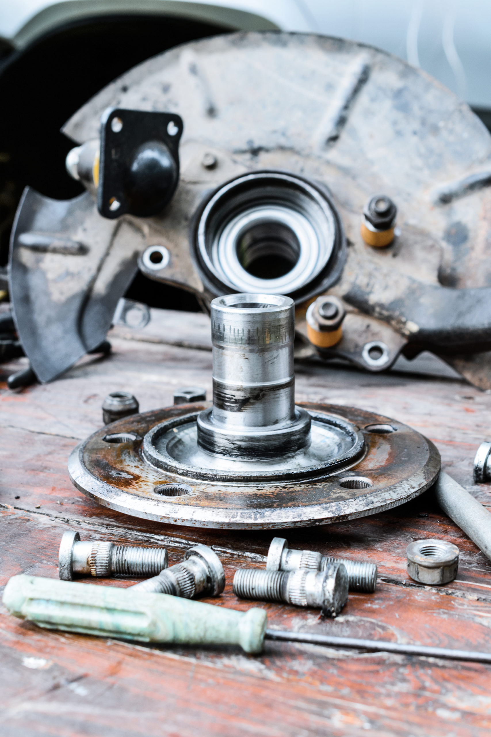 Old, oiled wheel hub lies on a wooden table