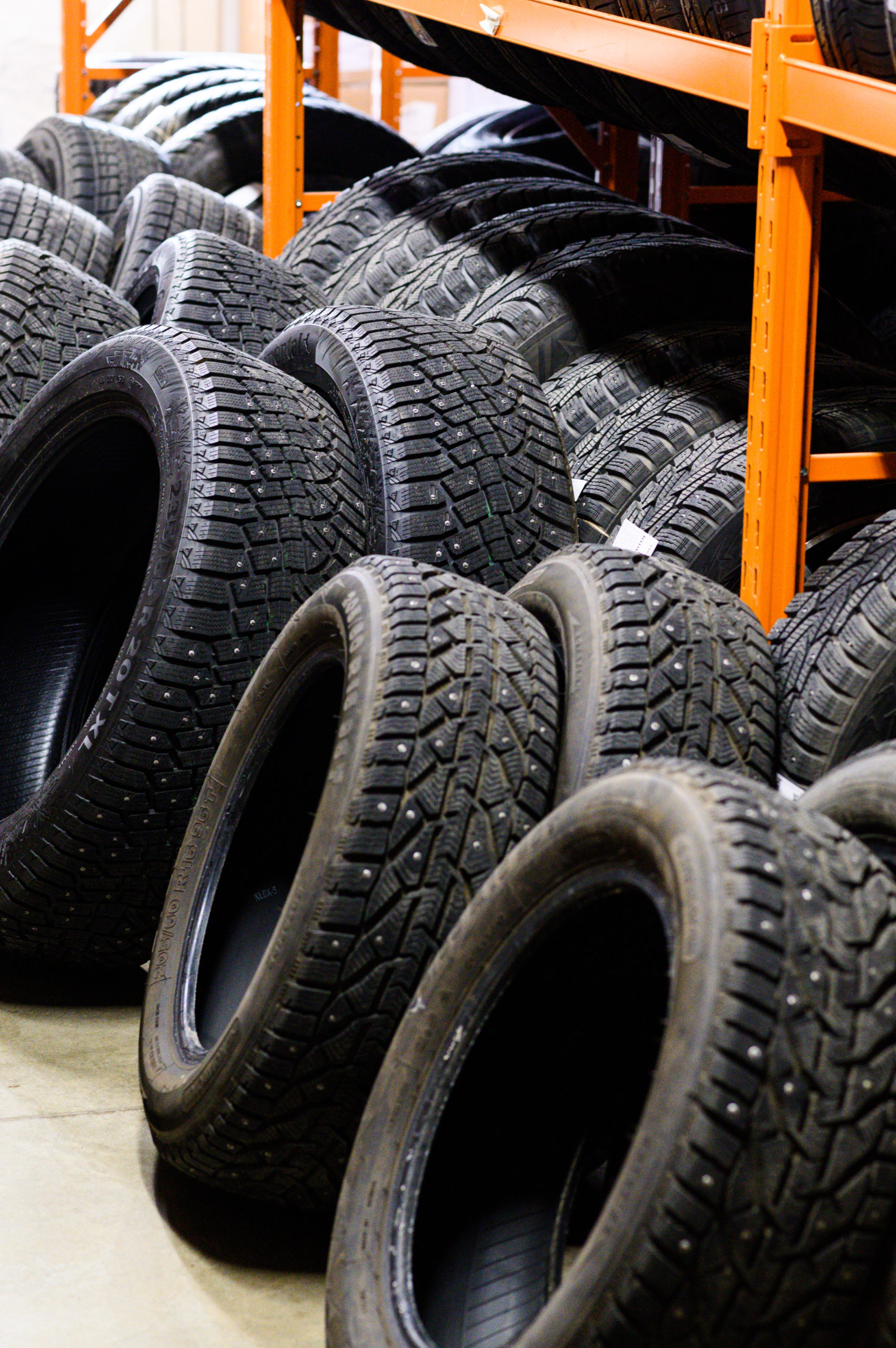 wall of alloy car wheels and pneumatic tires in store. seasonal wheel storage